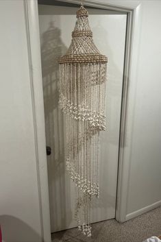 a white beaded chandelier hanging from the ceiling in front of a door