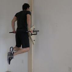 a man standing on top of a wall while holding onto a pair of skis