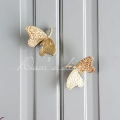 two gold butterflies hanging on the side of a door