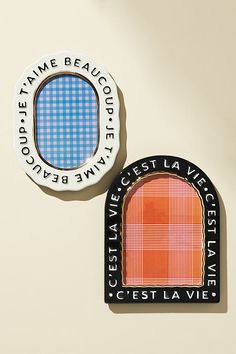 two badges on the side of a wall, one with an orange and blue plaid pattern