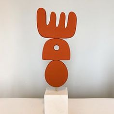 an orange sculpture sitting on top of a white table