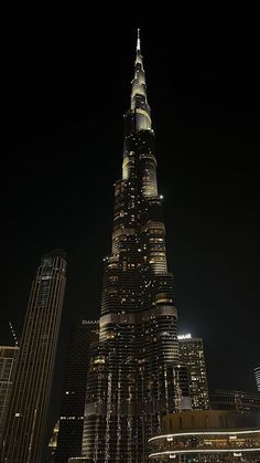 a very tall building lit up in the night sky with lights on it's sides