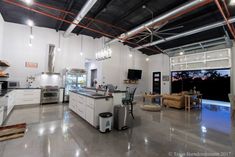 an open kitchen and living room area with stainless steel appliances in the middle of it