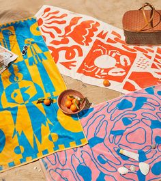 towels and bowls of fruit are laid out on the beach