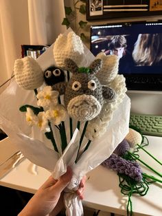 a person holding a bouquet of flowers in front of a computer