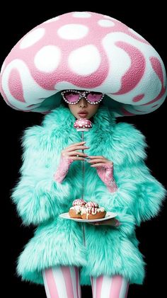 a woman in a pink and white outfit holding a plate with cake on top of it