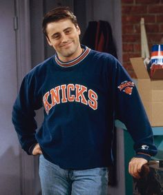 the young man is smiling while standing in front of a fire place with his hands on his hips