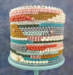 a stack of bracelets sitting on top of a blue table next to a wall