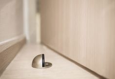 a door handle on the side of a wooden wall next to a white drawer with a black stripe