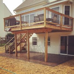 a deck with stairs and railings in front of a house