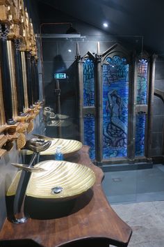 two sinks are in front of a stained glass shower stall with an artistic window behind them