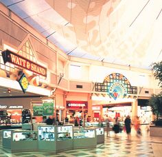 the inside of a shopping mall with people walking around