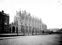 an old black and white photo of a street in front of a large building with many spires