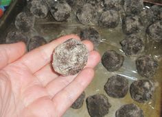 a person holding something in their hand next to some balls of food on a tray