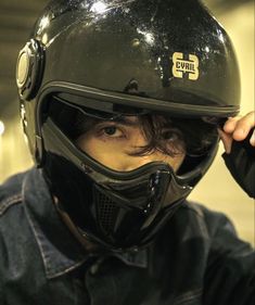 a man wearing a helmet and holding his hand up to his face