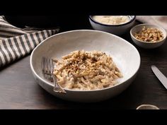 a bowl filled with food sitting on top of a wooden table next to two bowls