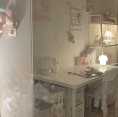 a white desk and chair in a room with stuffed animals on the wall next to it