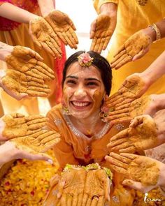 a woman is surrounded by hands covered in food