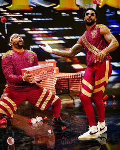 two men in red and gold outfits on stage