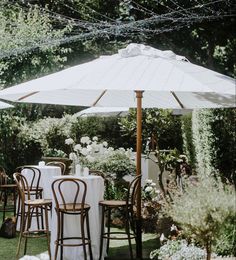 an outdoor dining area with tables, chairs and umbrellas set up for a meal