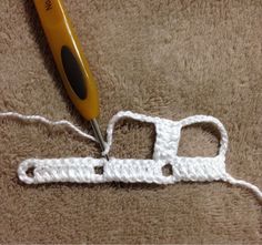 a pair of scissors are on top of a white crocheted piece of yarn