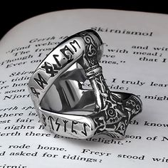 a close up of a ring on top of an open book with the words,