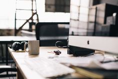 a coffee cup sitting on top of a desk next to a computer