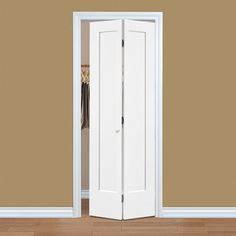 an open white door in the middle of a room with wood flooring and tan walls