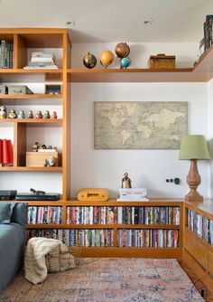 a living room filled with lots of books on top of wooden shelves next to a blue couch