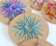 four paper circles with colored sticks in them on top of a white table and one circle is made out of cardboard