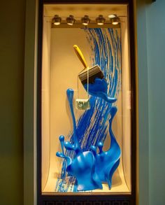 a display case with blue paint and a yellow toothbrush in the middle of it