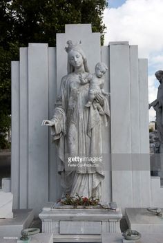 the statue of mary and child jesus in front of an obelisk