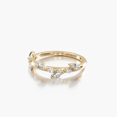 a rose gold ring with three pear shaped diamonds on the top and bottom, set against a white background