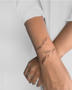 a woman's arm with a small tattoo on the left side of her wrist