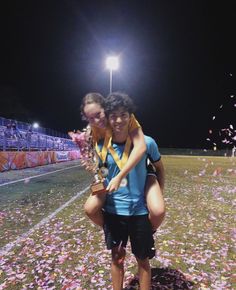 two people standing on a field with confetti in the air