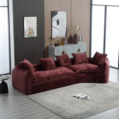 a red couch sitting on top of a rug in a living room