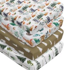 three sheets are stacked on top of each other in different patterns and colors, with trees and animals printed on them