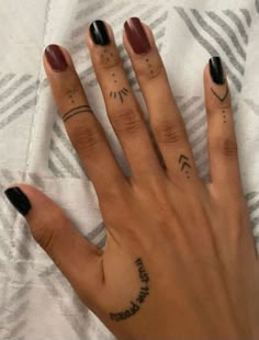 a woman's hand with two small tattoos on it