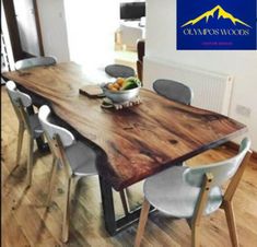 a wooden table with chairs around it and a bowl of fruit sitting on top of it