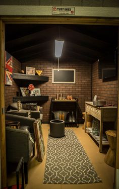 a living room filled with furniture and a flat screen tv mounted to the side of a brick wall