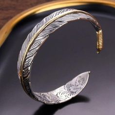 This ornate silver feather cuff bracelet is adjustable for a perfect fit. A great accessory for men and women, this fashionable bracelets makes a great gift for anyone who loves nature or dreams of going on an adventure. Feather Cuff Bracelet, Mens Bangles, Wrist Accessories, Feather Bracelet, Open Cuff Bracelet, Daily Jewelry, Silver Feather, Bracelet For Men, Mens Jewelry Bracelet