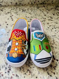 two pairs of shoes with cartoon characters painted on them