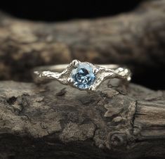 a close up view of a ring with a blue topazte stone in the center