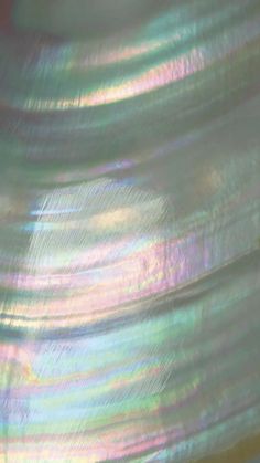 the back side of a white plastic object with iridescent colors and lines on it