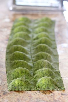 a close up of a piece of food on a counter with green stuff in the middle