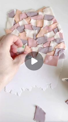 someone is making something out of paper and glues it onto the surface with their hands