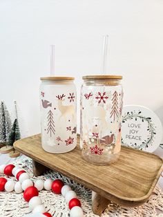 two decorated mason jars sitting on top of a wooden tray next to christmas decorations and ornaments