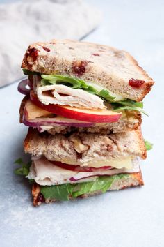 a sandwich with meat, lettuce and apple slices