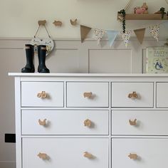 a white dresser with lots of drawers and decorations