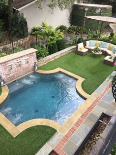 an outdoor pool with artificial grass and seating area next to the swimming pool is shown